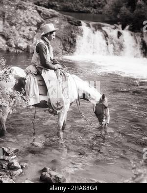 1930S COW-BOY À CHEVAL LAISSER SON CHEVAL DE PEINTURE BOIRE DE L'EAU DU RUISSEAU DANS LE PARC NATIONAL DE GLACIER MONTANA USA - H5001HAR001 HARS NATIONAL ÉTATS-UNIS COPIE ESPACE PLEINE LONGUEUR PERSONNES INSPIRATION SELLE COURS D'EAU ÉTATS-UNIS D'AMÉRIQUE SOINS MÂLES PONEY WESTERNPROFESSION CONFIANCE B&W REPOS AMÉRIQUE DU NORD COWBOYS NORTH AMERICAN PERFORMING ARTS CHEVAL OCCUPATION BONHEUR MAMMIFÈRES AVENTURE SA FORCE D'INTERPRÈTE DE LOISIRCASCADE CARRIÈRES CONNAISSANCES PARCS FIERTÉ RÉCRÉATIVE LAISSER SUR ENTERTAINER GLACIER OCCUPATIONS ACTEURS CONCEPTUELS MT STYLISÉ PINTO PARC NATIONAL CHAPS ANIMATEURSMAMMIFÈRE Banque D'Images