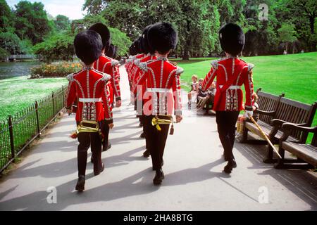 1970S BANC DE PARC POUR LES ENFANTS, REGARDEZ COLDSTREAM GUARDS DRUMMERS & BUGLERS DANS DES UNIFORMES DE CÉRÉMONIE PORTANT DES BARBES ST JAMES PARK LONDRES -KR31236 SPE001 HARS COMMUNICATION JUVÉNILE TRAVAIL D'ÉQUIPE BRITISH MARCHING UK STYLE DE VIE CÉLÉBRATION FEMMES BATTERIE PLEINE LONGUEUR PERSONNES INSPIRATION HOMMES LAITON DIVERTISSEMENT CONFIANCEANGLETERRE ANGLETERRE ÉTÉ ST LOISIRS ET EXCITATION PARCS FIERTÉ VUE ARRIÈRE SUR LA FORMATION OCCUPATIONS PASSÉ UNIFORMES CONNEXION CONCEPTUELLE DE DERRIÈREVILLES ÉLÉGANT VUE ARRIÈRE BEARSKINS BUGLERS BATTEURS JUVÉNILES PRÉCISION SAISON BUGLES CÉRÉMONIAL GRANDE BRETAGNE GARDES JAMES OLD FASHIED Banque D'Images