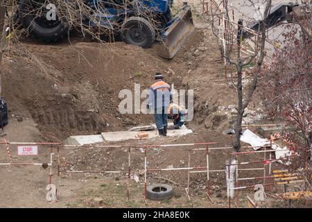 Tiraspol, République de Transnistrie non reconnue - 18 novembre 2021 Une équipe de travailleurs effectue des travaux de réparation sur un réseau de chauffage dans un ar résidentiel Banque D'Images