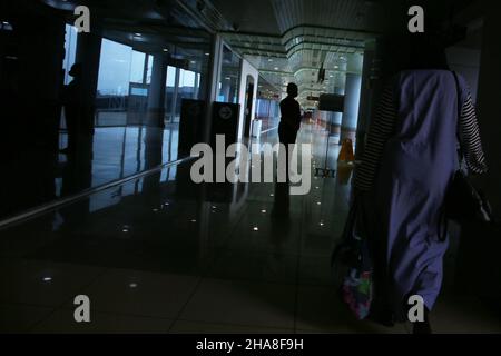 Palembang, Sumatera du Sud, Indonésie.11th décembre 2021.Silhouette d'un agent d'aéroport accueillant des passagers potentiels qui embarqueront à bord de l'avion Bombardier CRJ 1000 appartenant à PT Garuda Indonesia, de l'aéroport Sultan Mahmud Badaruddin II Palembang, Sumatra Sud, à l'aéroport Soekarno Hatta, Jakarta, Indonésie.Le Bombardier CRJ1000 a été développé par Bombardier Aéronautique, une entreprise canadienne.Cet avion est équipé d'un système qui permet à l'avion d'éviter les collisions, ainsi que de vérifier les conditions météorologiques dans la région et le passage prévu, il est également considéré comme un peu économe en carburant Banque D'Images