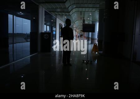 Palembang, Sumatera du Sud, Indonésie.11th décembre 2021.Silhouette d'un agent d'aéroport accueillant des passagers potentiels qui embarqueront à bord de l'avion Bombardier CRJ 1000 appartenant à PT Garuda Indonesia, de l'aéroport Sultan Mahmud Badaruddin II Palembang, Sumatra Sud, à l'aéroport Soekarno Hatta, Jakarta, Indonésie.Le Bombardier CRJ1000 a été développé par Bombardier Aéronautique, une entreprise canadienne.Cet avion est équipé d'un système qui permet à l'avion d'éviter les collisions, ainsi que de vérifier les conditions météorologiques dans la région et le passage prévu, il est également considéré comme un peu économe en carburant Banque D'Images