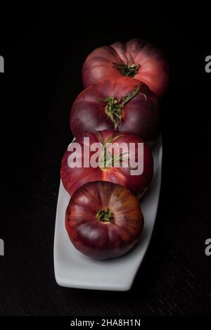 Tomates de la nouvelle variété Mar Azul, sur fond noir. Banque D'Images