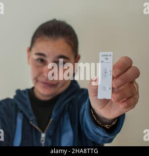 le visage d'une femme floue montre un test rapide positif de covid-19 Banque D'Images