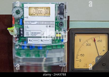 Compteur d'électricité moderne informatisé et ancien voltmètre à cadran d'électricité dans une usine industrielle Banque D'Images