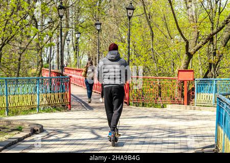 Un homme à cheval électrique noir en ville. Banque D'Images