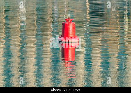 Bouée de navigation rouge flottante sur la surface de l'eau de la rivière. Banque D'Images