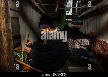 Srinagar, Cachemire sous contrôle indien.11th décembre 2021.Les artisans serpentent des tapis à leur atelier de la ville de Srinagar, capitale estivale du Cachemire sous contrôle indien, le 11 décembre 2021.Crédit : Javed Dar/Xinhua/Alay Live News Banque D'Images