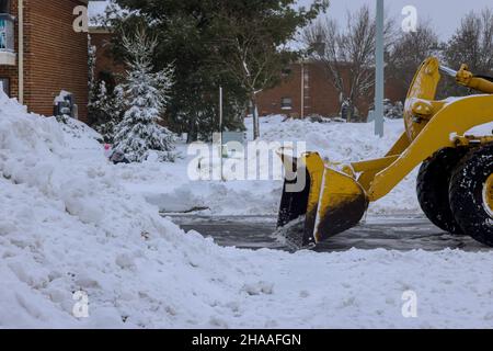 Le véhicule de chasse-neige déneigement les routes enneigées pendant la tempête de neige hivernale Banque D'Images