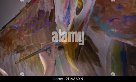 Concepteur de l'artiste dessine un aigle sur le mur. Décorateur artisan photo peintures à l'acrylique couleur d'huile. Peintre peintre vêtu de couche de peinture. À l'intérieur. Banque D'Images
