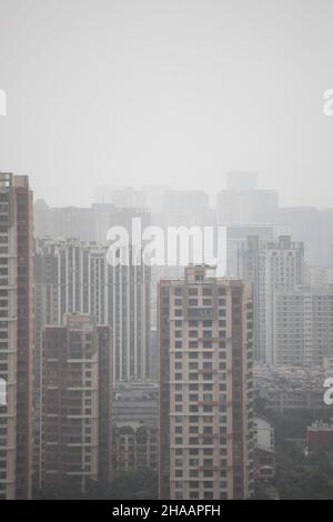 Brumgy, smoggy, déprimant ville chinoise avec de nombreux bâtiments ND GRUES Banque D'Images