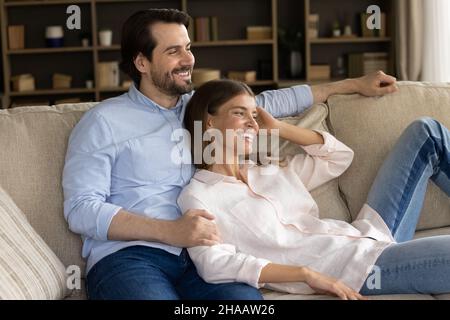 Un jeune couple heureux se détendant à la maison, en profitant des loisirs sur le canapé Banque D'Images