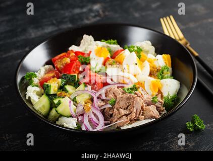 Une alimentation saine.Salade de thon avec œufs, laitue, tomates cerises, concombre et oignons rouges.Cuisine française. Banque D'Images