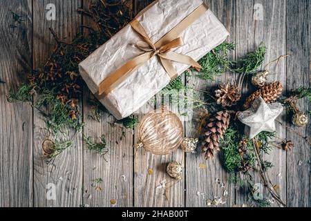 Composition de Noël à plat avec boîte cadeau sur une surface en bois. Banque D'Images