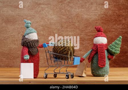 Gnomes tricotés faits main avec arbre de Noël et boule de Noël dans un panier sur une table en bois.Concept de Noël. Banque D'Images