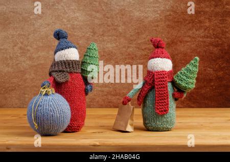 Gnomes tricotés faits main avec arbres de Noël et boule de Noël sur table en bois.Concept de Noël. Banque D'Images