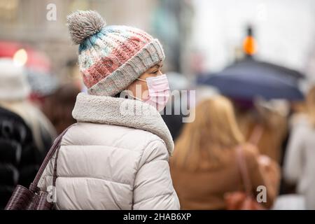 Londres, Royaume-Uni.11th décembre 2021.Un shopper portant un masque facial comme mesure préventive contre la propagation du covid-19 vu marcher le long d'Oxford Circus à Londres.Crédit : SOPA Images Limited/Alamy Live News Banque D'Images