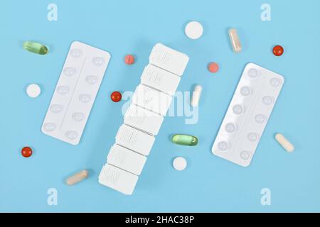 Pilules, capsules, blister et boîte de pilules sur fond bleu Banque D'Images