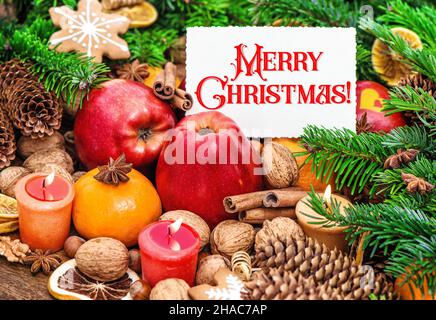 Concept de carte de Noël.Bougies allumées décoration avec biscuits, fruits, noix, épices Banque D'Images