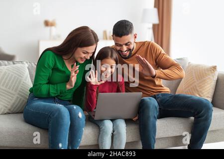 La famille arabe fait des appels vidéo en utilisant un ordinateur portable et en se faisant passer les mains Banque D'Images