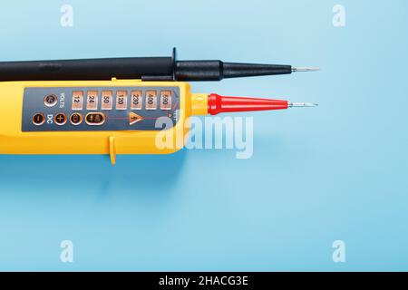Indicateur de tension jaune sur fond bleu.Espace libre Test et vérification des réseaux électriques Banque D'Images