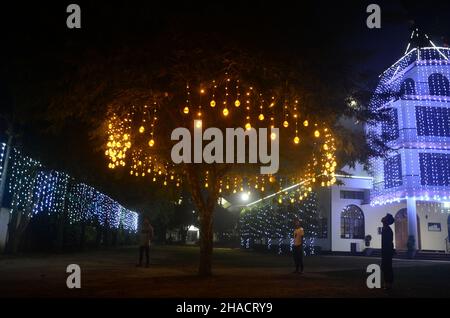 Dimapur, Inde.12th décembre 2021.Les piétons indiens admirent la décoration de la Nativiterie de Jésus exposée devant l'église baptiste de Mao, alors qu'elle est éclairée avant le festival de Noël à Dimapur, dans l'État du Nagaland, au nord-est de l'Inde.Credit: Caisii Mao/Alay Live News Banque D'Images