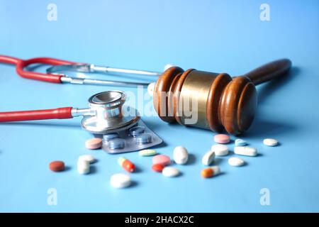 Vue de dessus du gavel, du stéthoscope et des pilules sur fond blanc Banque D'Images