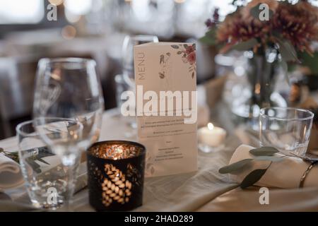 Vaisselle classique, bougie et menu sur la table de mariage Banque D'Images