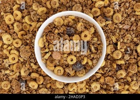 granola croquante avec noix et fruits dans un bol en céramique sur fond de muesli, vue du dessus, concept de nourriture saine, délicieux petit déjeuner Banque D'Images