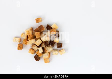 pile de croûtons de pain faits maison isolés sur fond blanc, vue de dessus, cubes de pain croustillants, chapelure de seigle et de blé, crouoton ou crackers torréfiés cub Banque D'Images