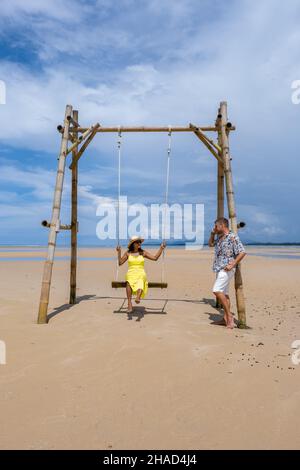 Couple homme et femmes se détendant dans un hamac sur la plage de Phuket Nai yang plage Thaïlande. Ciel bleu avec un hamac sur la plage Banque D'Images