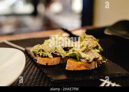 Cuisine fusion servie dans un restaurant, pincho espagnol avec salade, sauce au curry et poulet Banque D'Images