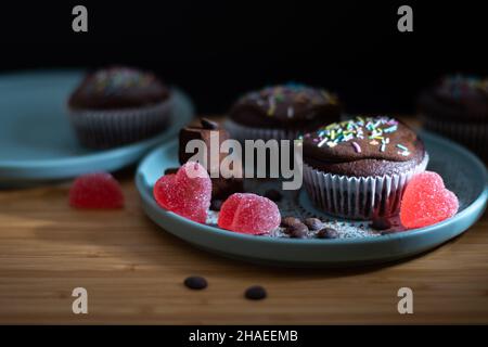 Délicieux muffin au chocolat avec topin de crème blanche aux saupoudrées colorées, truffes et bonbons en forme de coeur pour la fête de la Saint Valentin pour l'amour Banque D'Images