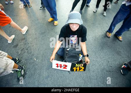 Bangkok, Thaïlande.12th décembre 2021.Un manifestant est assis sur le sol tout en tenant des plaques pendant la démonstration.Les manifestants exigent la démission du Premier ministre Prayuth Chan-ocha et l'abolition de la loi de 112 sur la lèse-majeste.Crédit : SOPA Images Limited/Alamy Live News Banque D'Images