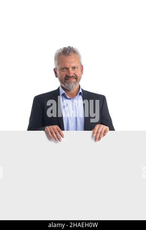A smiling businesswoman holding a white panneau et gesticulant isolé sur fond blanc Banque D'Images