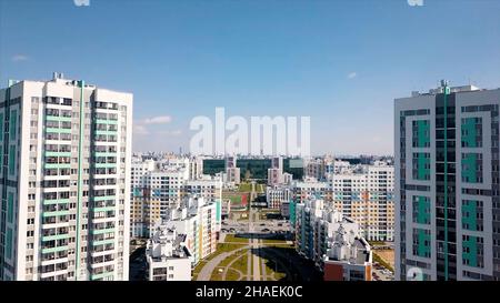 Vue aérienne d'un grand quartier de la ville avec des rues ensoleillées et des bâtiments résidentiels de haute élévation sur fond bleu ciel.Vidéo.Belle ville colorée, Banque D'Images