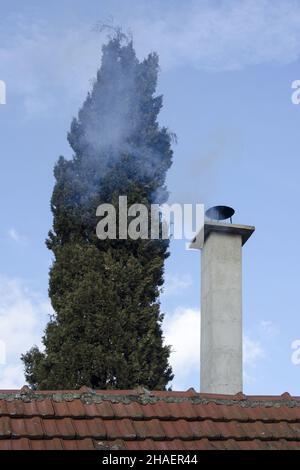 Un faible angle d'une cheminée Smokey en milieu d'hiver sur ciel bleu Banque D'Images