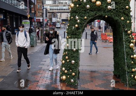 Les acheteurs de Noël portant des masques de visage viennent dans le centre-ville alors que l'émergence de la nouvelle variante Covid-19 Omicron se poursuit le 12th décembre 2021 à Birmingham, au Royaume-Uni.Les restrictions ont augmenté il y a environ 2 semaines, rendant les couvertures de visage obligatoires dans les magasins et dans les transports publics.Malgré les nouvelles règles, la majorité des gens ne portent pas de masques à l'extérieur dans les zones commerçantes bondées ni à l'intérieur du centre commercial. Banque D'Images