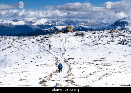 Les touristes font de la randonnée le long d'un sentier de montagne enneigé dans le parc national Jasper Canada Banque D'Images