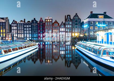 Maisons dansantes au canal d'Amsterdam Damrak la nuit, Hollande, pays-Bas Banque D'Images