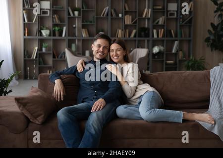 Portrait d'un couple de famille souriant reposant sur un canapé. Banque D'Images