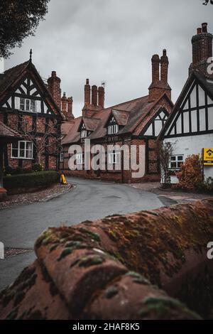 Rue de la maison Tudor avec vue sur une église fortifiée dans Great Budworth.Great Budworth est un village et une paroisse civile à Cheshire, en Angleterre. Banque D'Images