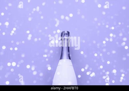 Bouteille de champagne sur fond de lilas très péri.Concept de Noël, d'anniversaire, de Bachelorette ou de mariage.Style de pose à plat.Couleur de 2022 très Peri. Banque D'Images