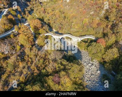 Vue aérienne de l'ancien pont en pierre à trois voûtes de Kalogeriko sur le canyon Vikos, Zagorohoria, Grèce, Europe Banque D'Images