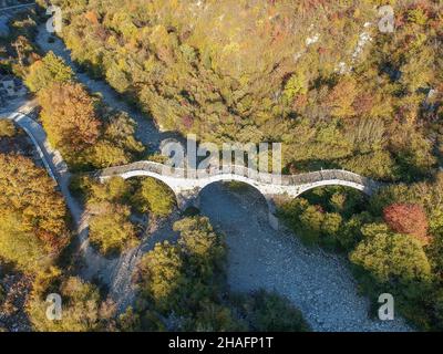 Vue aérienne de l'ancien pont en pierre à trois voûtes de Kalogeriko sur le canyon Vikos, Zagorohoria, Grèce, Europe Banque D'Images