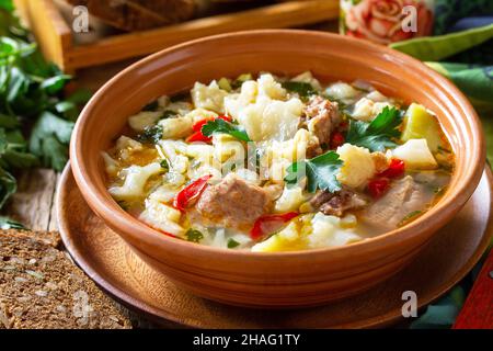 Soupe traditionnelle hongroise épaisse avec bœuf, légumes et boulettes sur une table en bois.Dîner chaud ou déjeuner. Banque D'Images