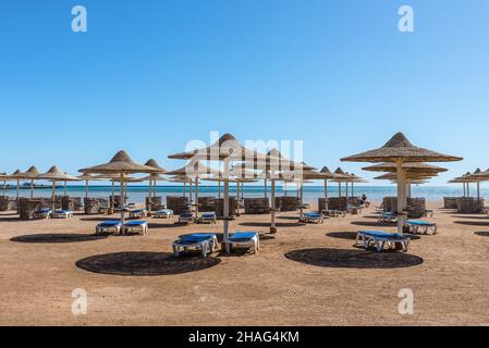 Hurghada, Egypte - 25 mai 2021: Parasols et chaises longues sur une plage vide du Stella Di Mare Beach Resort and Spa situé dans la baie de Makadi, qui o Banque D'Images