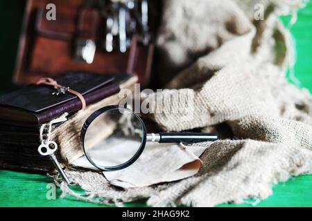 Vieux sac en cuir avec une loupe sur une table en bois brun voyageur espace de copie de fond. Banque D'Images