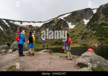 KARPACZ, POLOGNE - 09 mai 2018 : le groupe de personnes se trouvant au bord d'un lac dans les montagnes Karkonosze. Banque D'Images