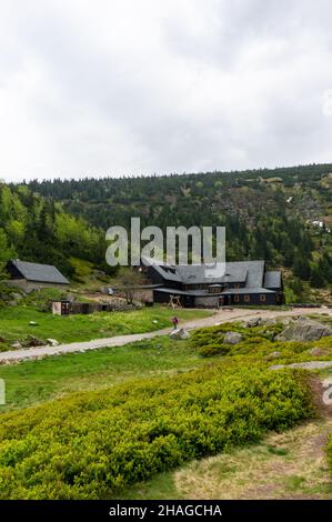 KARPACZ, POLOGNE - 09 mai 2018 : une photo verticale d'arbustes verts, d'arbres et de sentiers près d'un bâtiment en bois sur la montagne Karkonosze. Banque D'Images