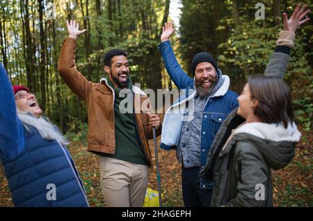 Groupe diversifié de bénévoles heureux célébrant ensemble le succès après le nettoyage de la forêt. Banque D'Images